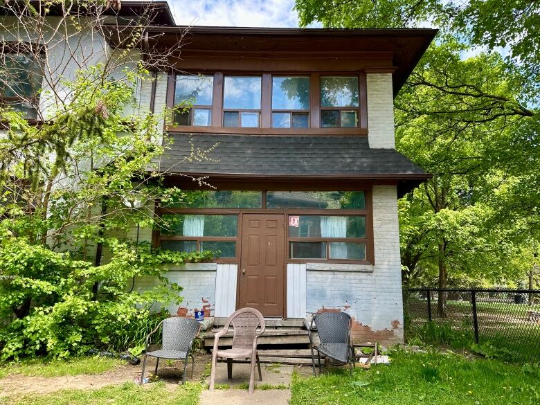 side door of house with broken chair out front