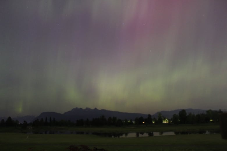 The northern lights are pictured above mountains.