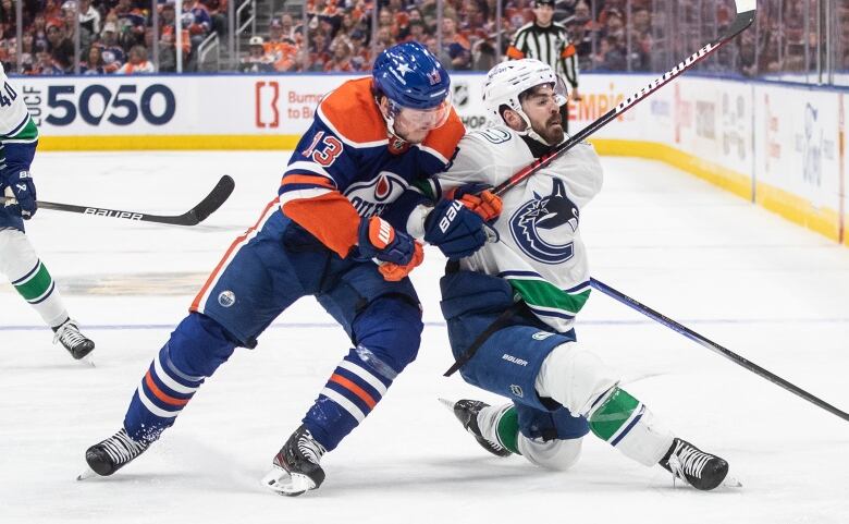 Two hockey players vie for a loose puck.