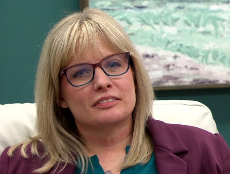 A blonde haired woman with glasses. 