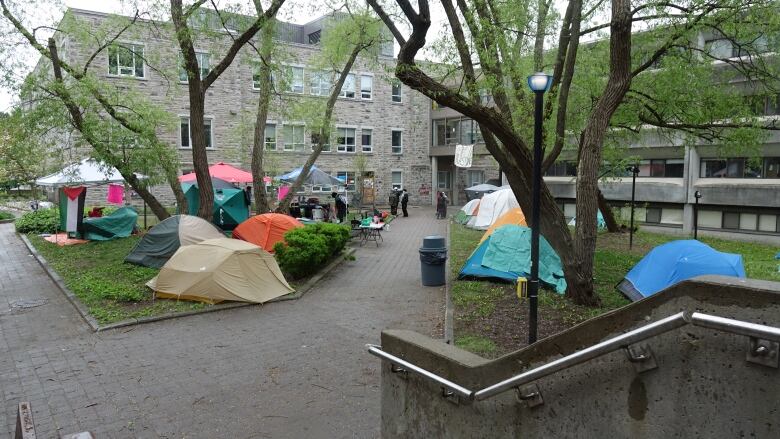 Several brightly-coloured tents can be seen covering the grass between paved stone pathways.