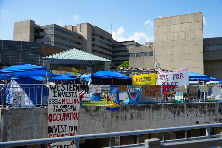 A sprawling, messy encampment including tents and signs at Western University. 