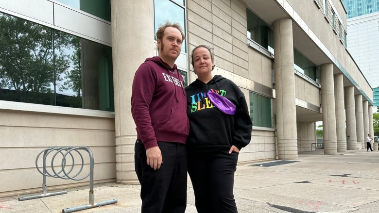 A woman and a man outside a courthouse.