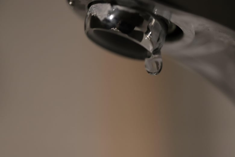 a drop of water drips from a tap.