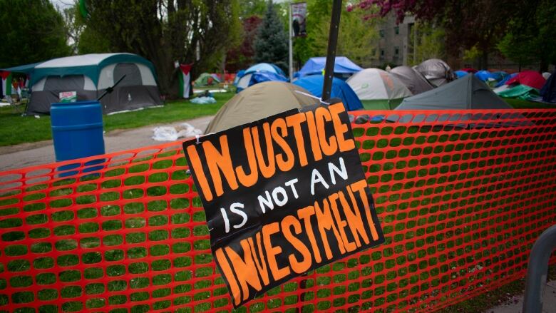 A fence in front of tents.