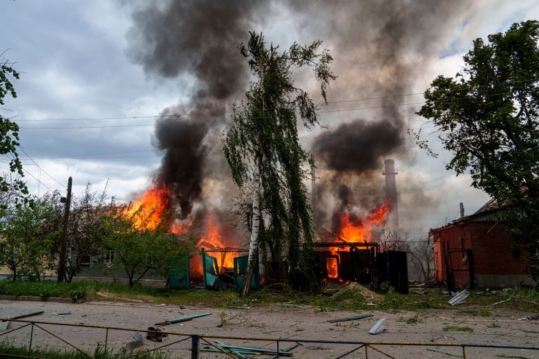 Homes are seen burning in Vovchansk, Ukraine, following Russian airstrikes on Saturday, May 11, 2024.