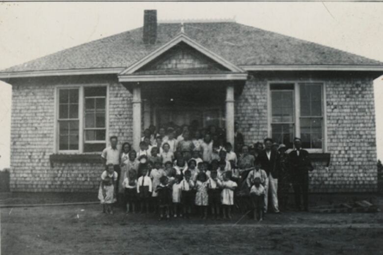 Old photo of white building.