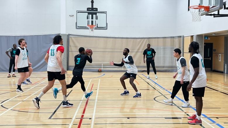 Basketball players practice on an indoor court