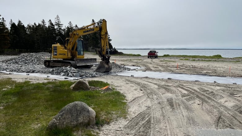 An excavator is shown by the beach laying down rocks that will form a new access road to part of the campground at Rissers Beach Provincial Park.