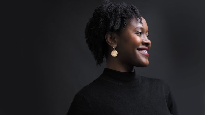 A portrait of a woman smiling and looking off to the side. 