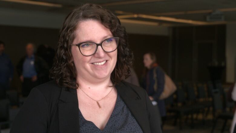 A smiling woman with glasses.