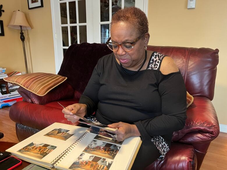 A woman looking at a photo album. 