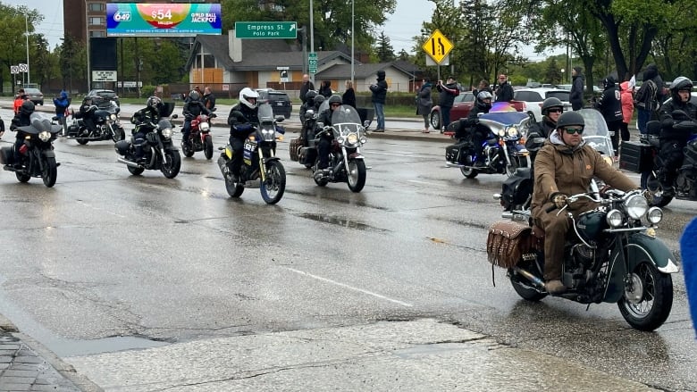 A group of motorcyclists are pictured riding down a road.