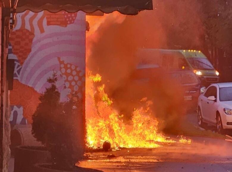 A fire in front of a building is pictured.