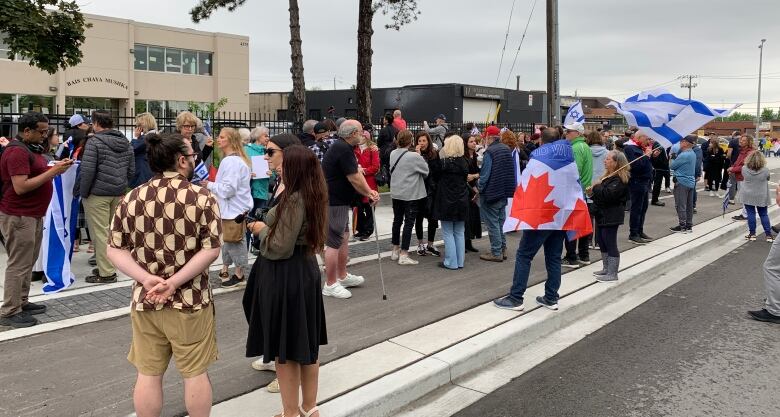 A crowd gathers for a rally outside a school.