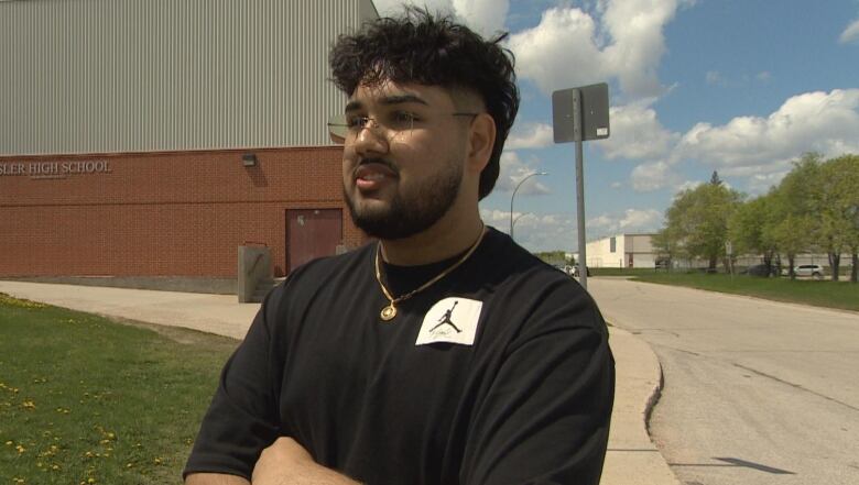 A teenage boy is pictured speaking outside of a school.