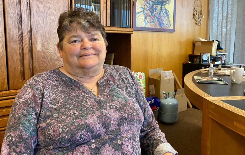 A woman sits in an office.