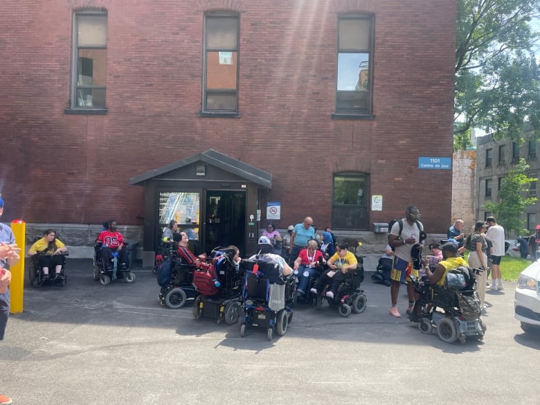 A group of people in wheelchairs gathered outdoors for a rally. 