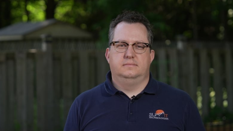 A man wearing glasses is pictured in his backyard.