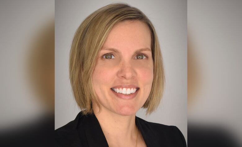 Smiling blond woman with short bob-style haircut. 