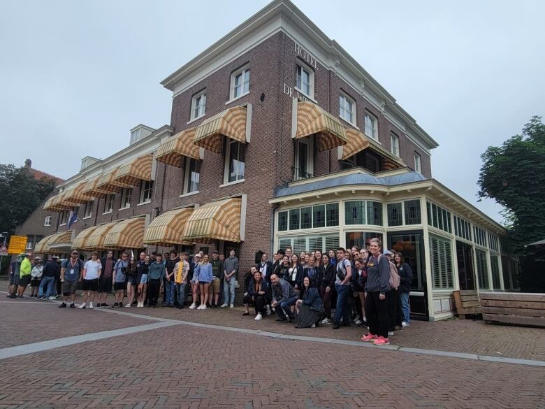 A group standing in front of a hotel