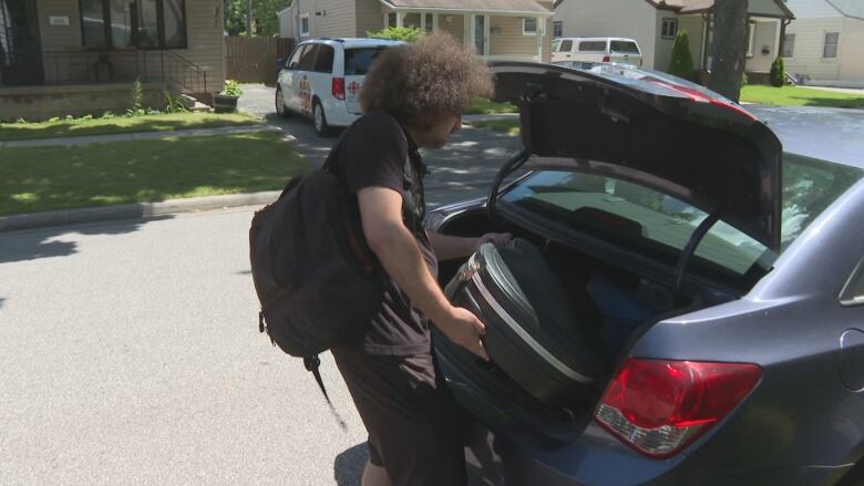 Steuer loads his music equipment into the back of his car in Windsor, Ont.