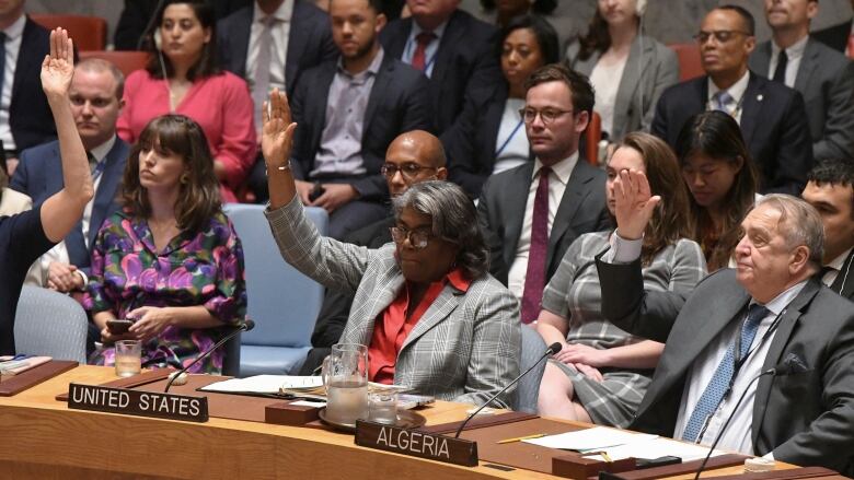 A woman raises her hand to vote