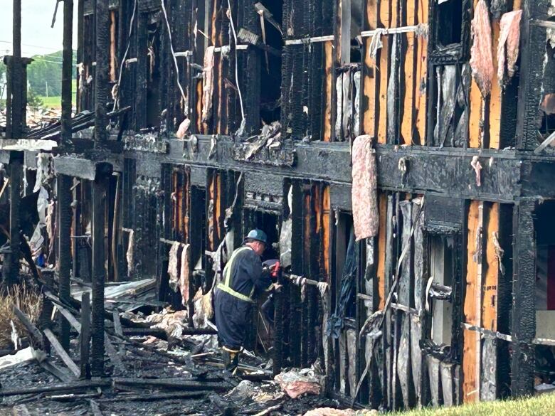 A Charlottetown firefighter sifts through the rubble on Tuesday.