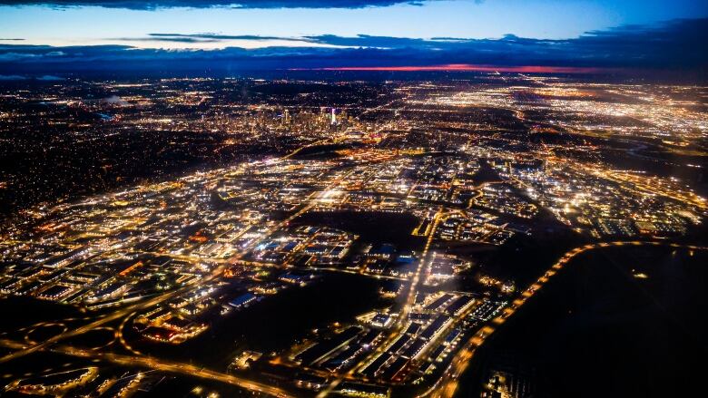 A cityscape is seen from the air at night.