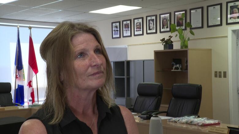 A woman stands in an office.