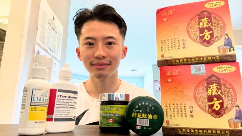 A man stands between two piles of boxes and jars, one of medicine and one of Chinese traditional medicine. 