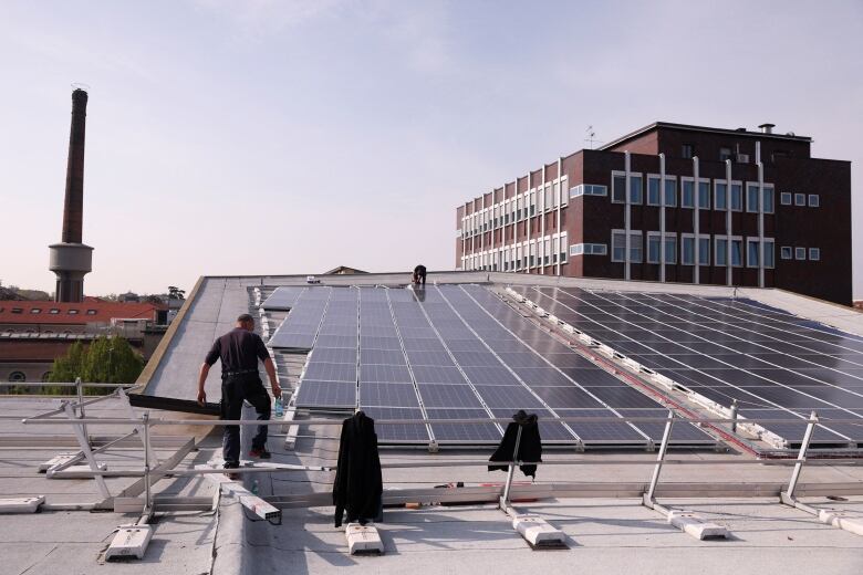 Men on a rooftop working with solar panels