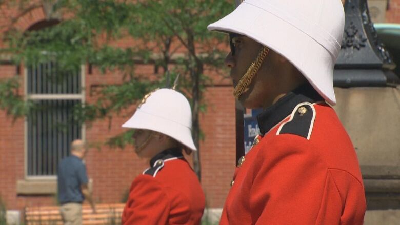 Two members of the ceremonial guard program stand outside city hall.