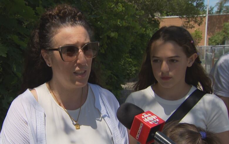 A woman and her daughter give an interview.