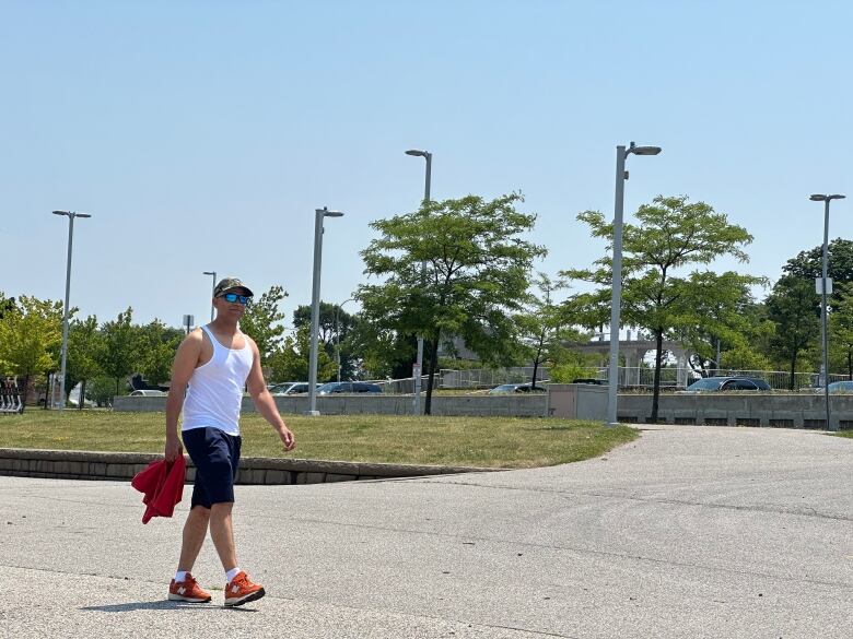 A man walks along a paved trail