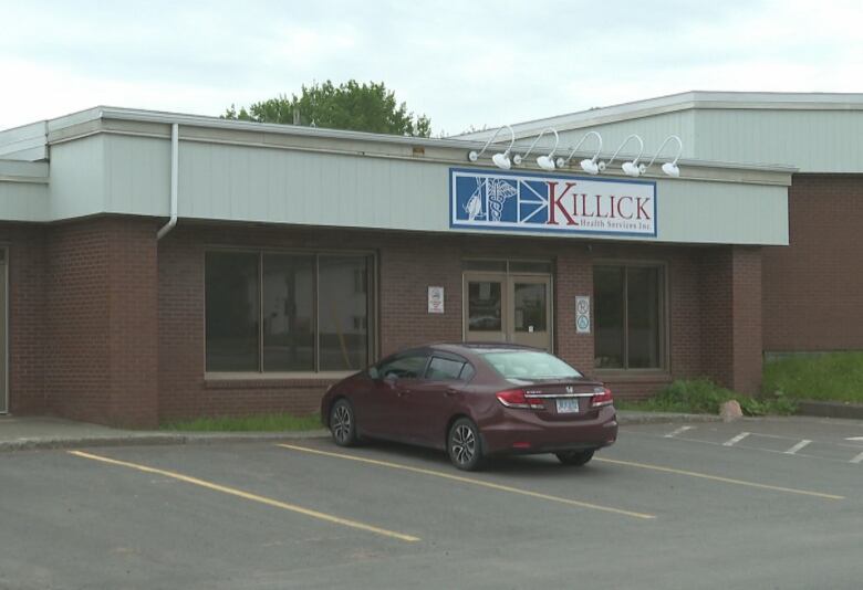 Brown building with car parked in front of its doors.