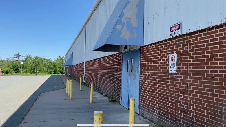 A brick building with yellow bollards in front of it.