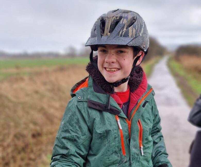 A smiling boy on a bicycle