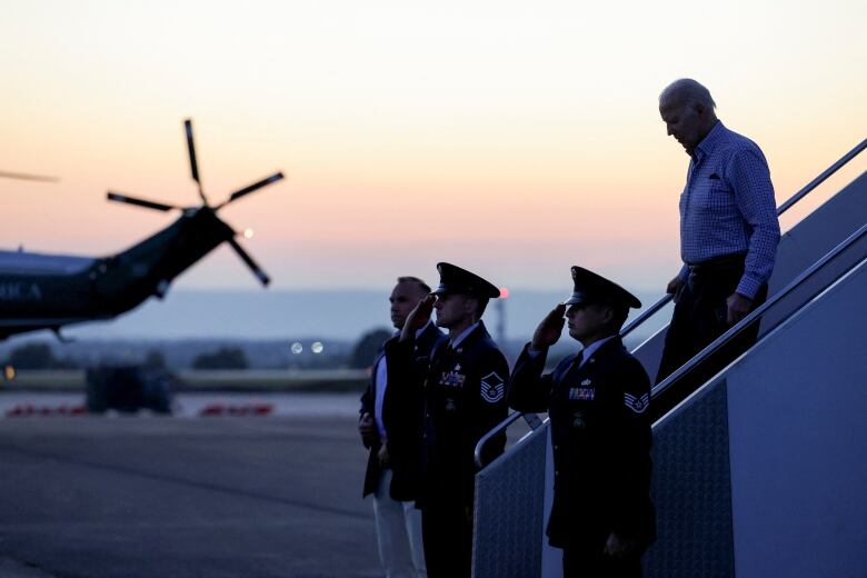 Silhouette of Biden walking down the stairs of Air Force One in the sunset