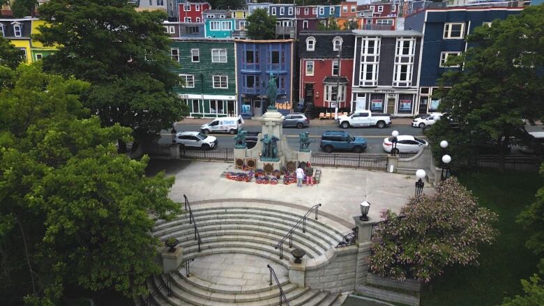 A monument surrounded by trees and colourful buildings. 