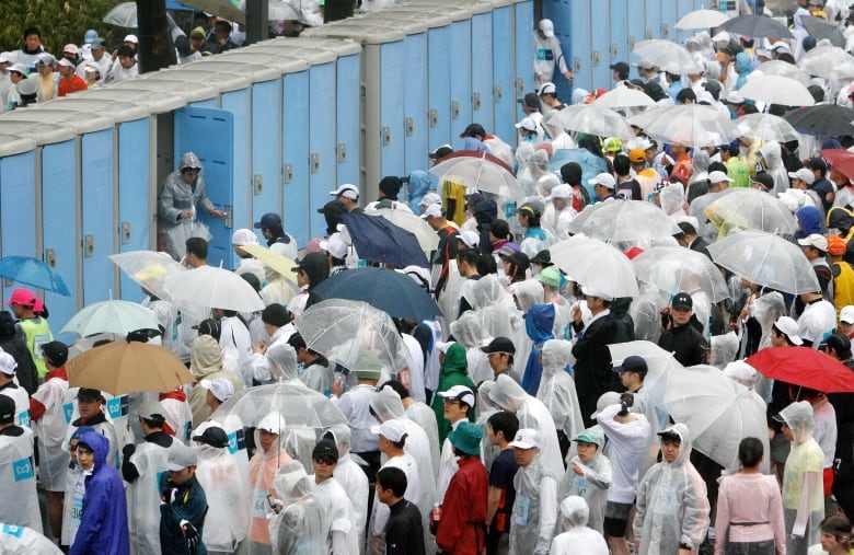 People wait in line for portable toilets