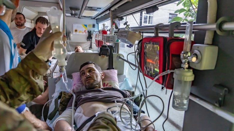 An injured soldier gets medical care inside a transport bus