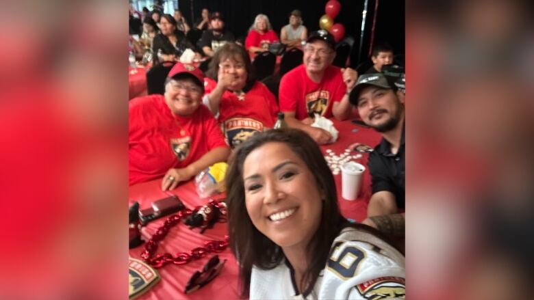 A selfie of a person and a goup of others seated at a table. 