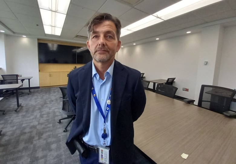 Man in blue suit standing in a board room.