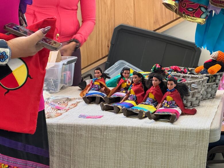 Multiple dolls sit on a table