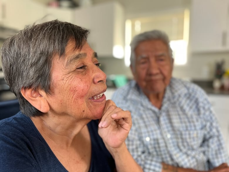 A couple sit at a kitchen table in Lytton, B.C.