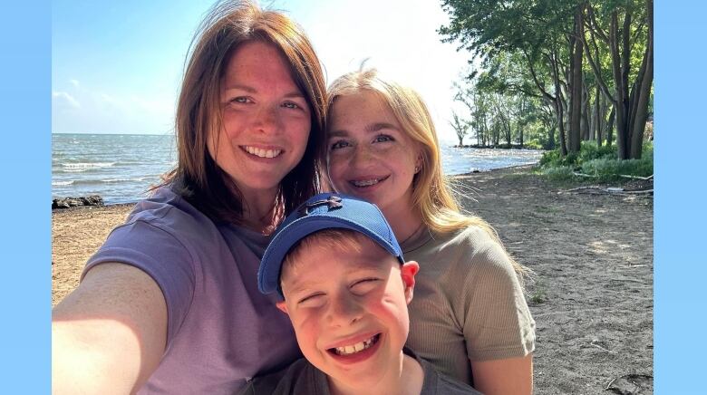 A woman and her two children on a beach.