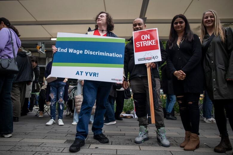 Workers holding signs saying 