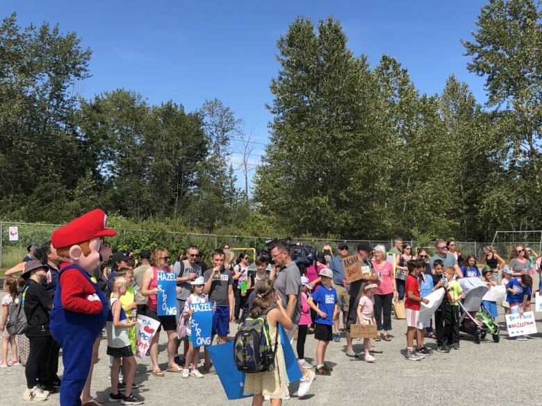 A large group of people gathers outside.