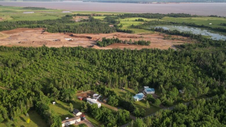 a bird's eye view of a quarry, trees and homes